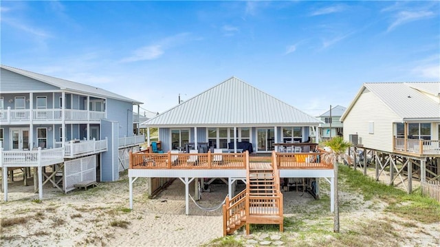 back of property with a wooden deck and metal roof