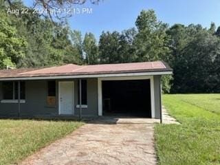 view of front of house featuring a front yard, concrete driveway, and an attached garage