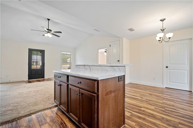 kitchen featuring pendant lighting, lofted ceiling, a center island, wood-type flooring, and ceiling fan with notable chandelier