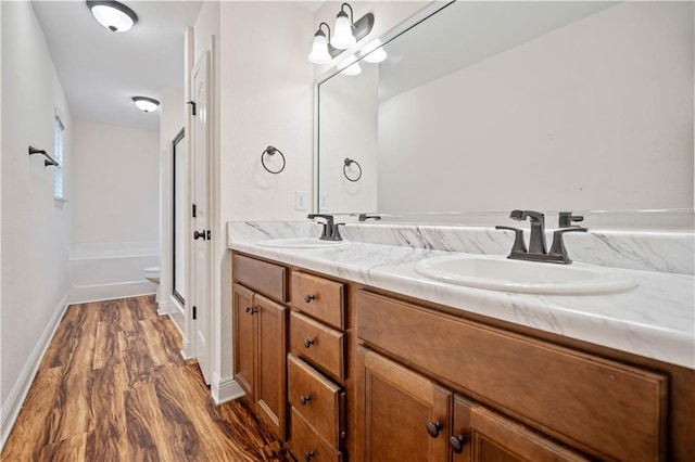 bathroom with wood-type flooring, a shower, vanity, and toilet