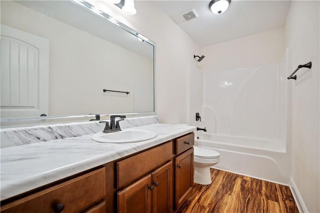 full bathroom featuring vanity, hardwood / wood-style flooring, toilet, and washtub / shower combination