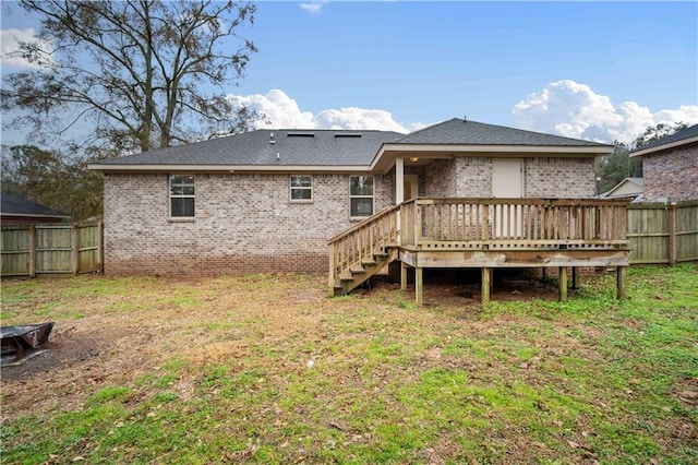 back of property with a wooden deck and a yard