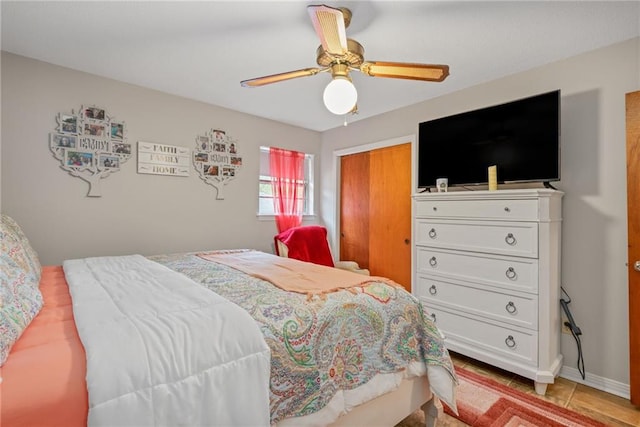 tiled bedroom featuring ceiling fan and a closet