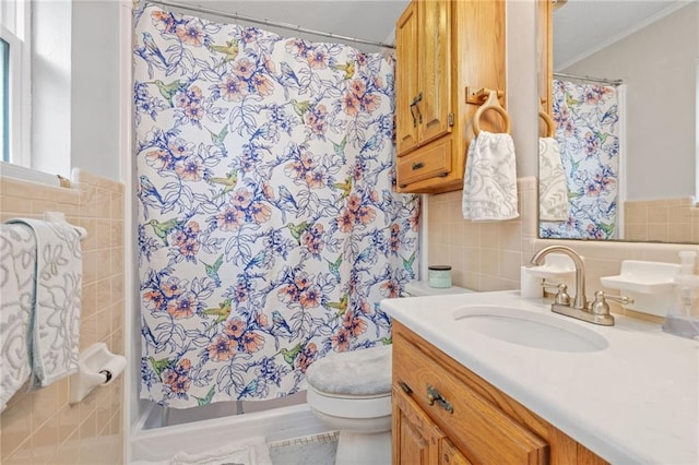 bathroom with toilet, crown molding, tile walls, vanity, and curtained shower