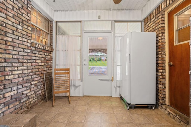 entryway featuring brick wall