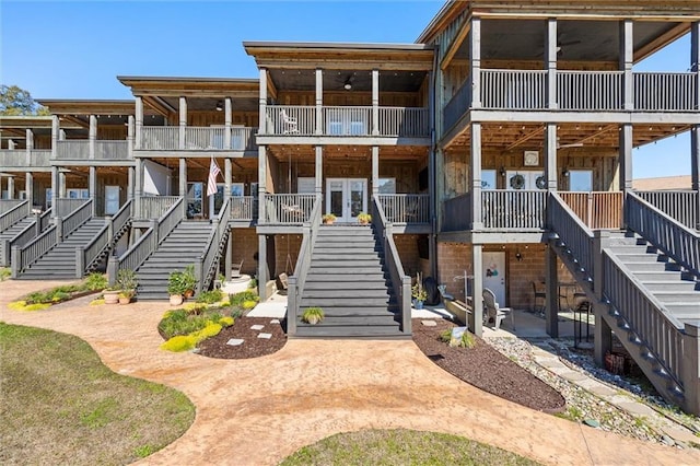 view of front of house with a patio, stairway, and a ceiling fan