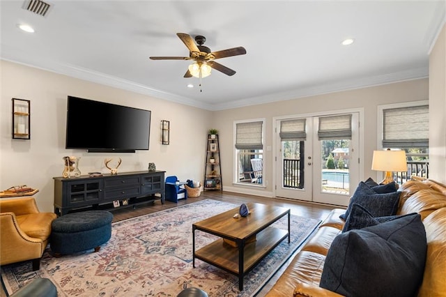 living room with french doors, crown molding, recessed lighting, visible vents, and wood finished floors