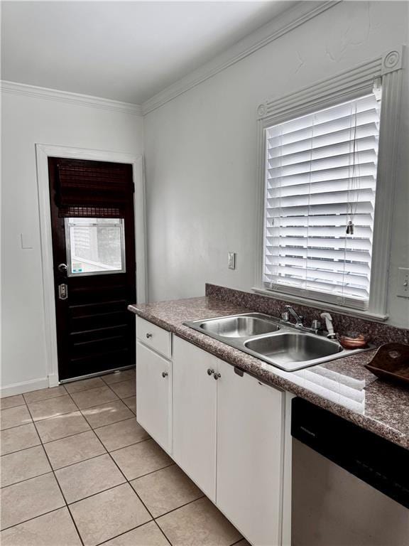 kitchen featuring dishwasher, sink, light tile patterned flooring, crown molding, and white cabinets