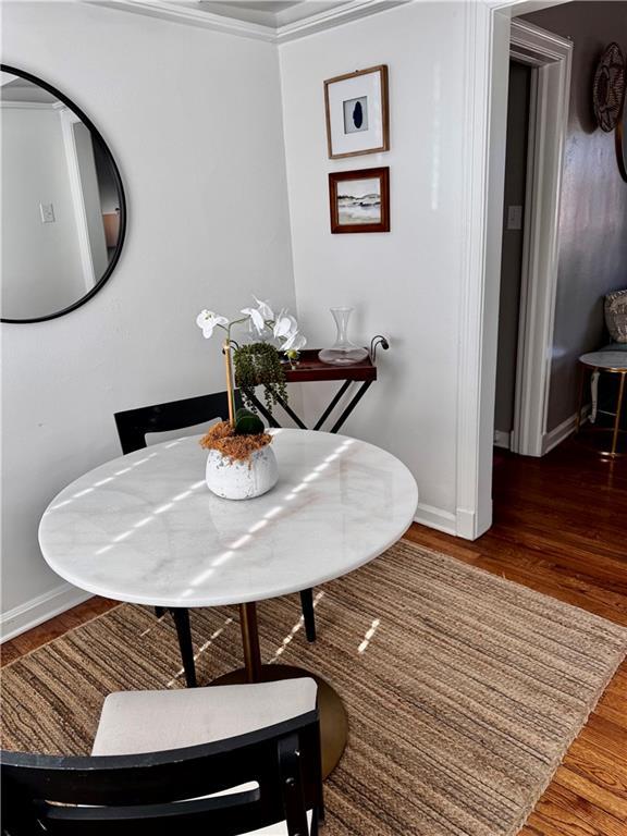 dining space with crown molding and dark hardwood / wood-style floors