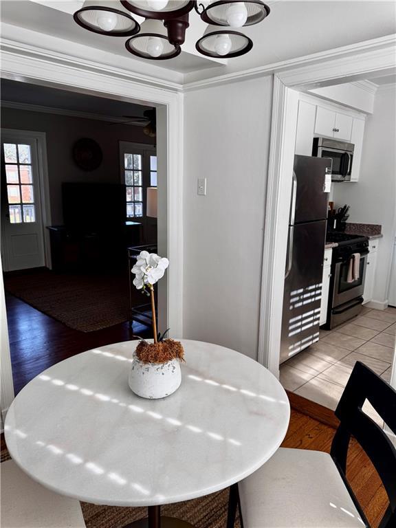 dining area featuring crown molding, a healthy amount of sunlight, and light wood-type flooring