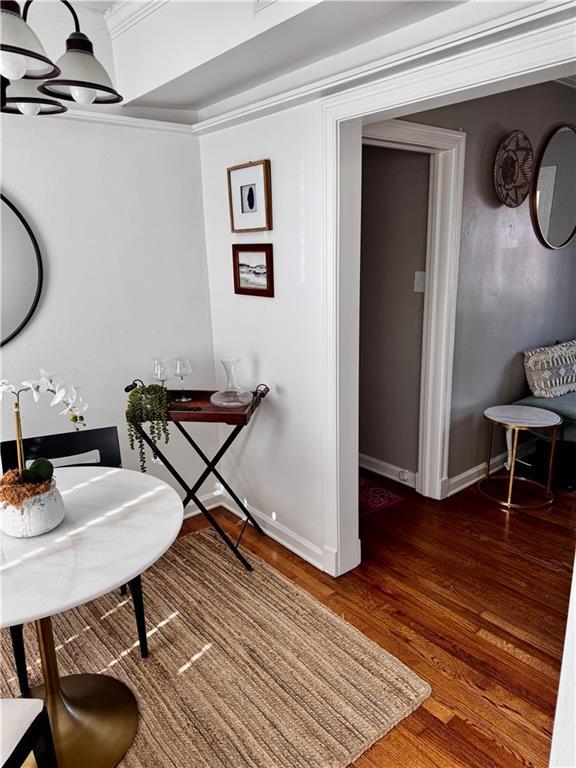 interior space featuring dark hardwood / wood-style floors, ornamental molding, and an inviting chandelier