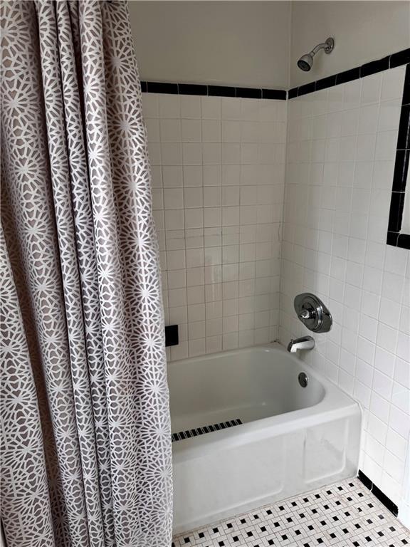 bathroom featuring tile patterned flooring and shower / bath combination with curtain