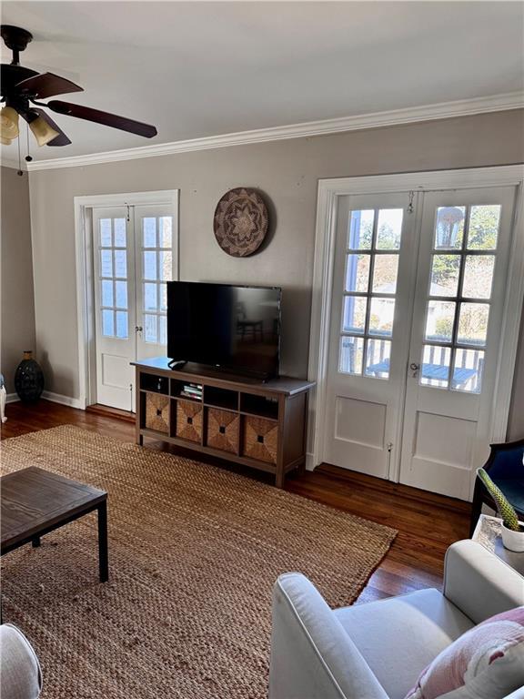 living room featuring dark hardwood / wood-style flooring, ceiling fan, french doors, and ornamental molding