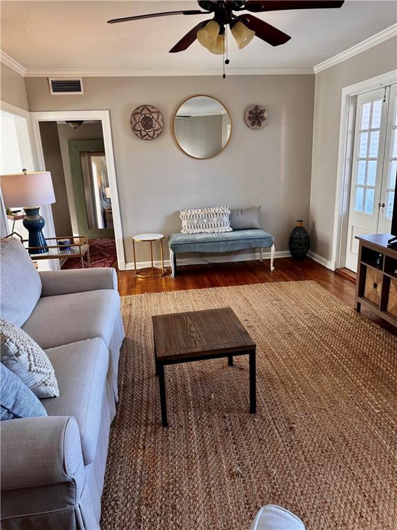 living room with ceiling fan, ornamental molding, and hardwood / wood-style flooring