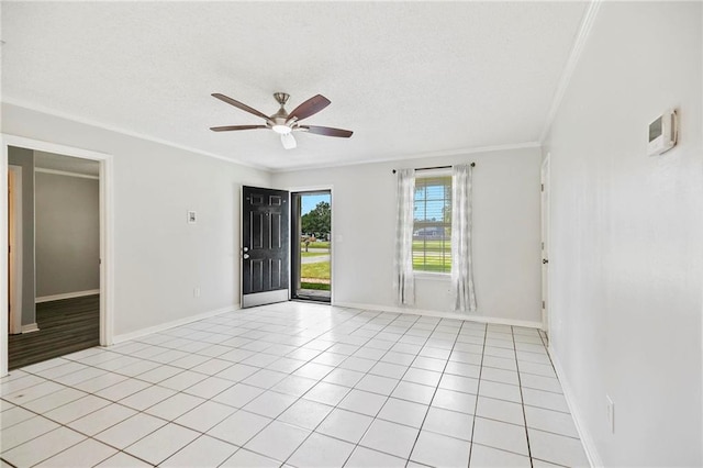 spare room featuring ceiling fan, ornamental molding, and light tile patterned floors