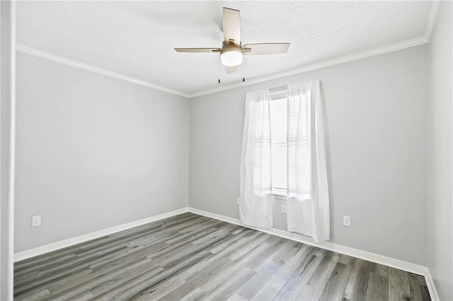 empty room featuring ceiling fan, crown molding, and wood-type flooring