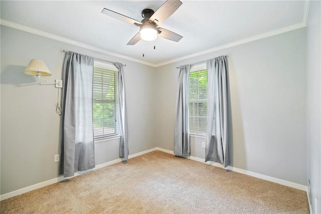 carpeted spare room featuring ceiling fan, a wealth of natural light, and ornamental molding