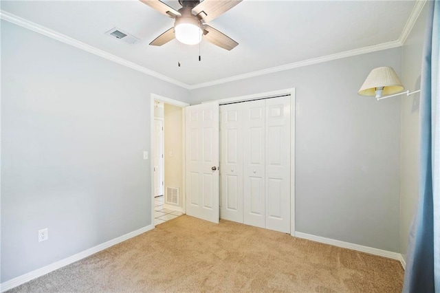 unfurnished bedroom with light colored carpet, a closet, ornamental molding, and ceiling fan