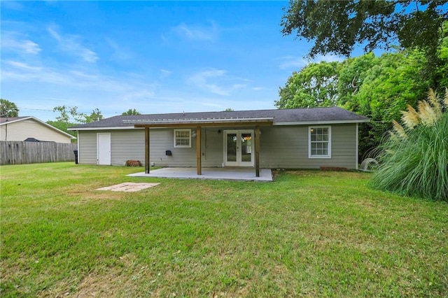 back of property featuring french doors, a patio area, and a lawn