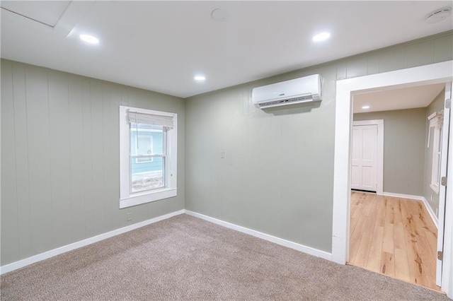 unfurnished room featuring a wall mounted AC and light hardwood / wood-style flooring