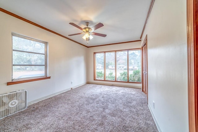 empty room featuring ceiling fan, ornamental molding, and carpet floors