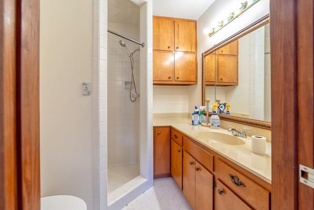 bathroom featuring vanity, toilet, and tiled shower