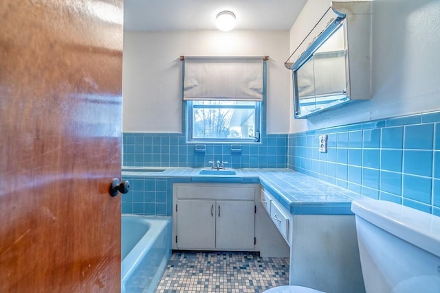 bathroom with vanity, toilet, and a tub