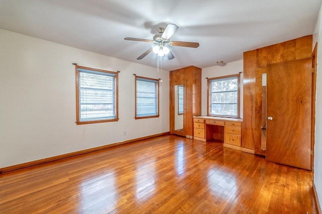 unfurnished bedroom featuring built in desk and wood-type flooring