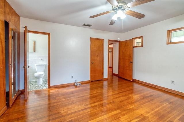 unfurnished bedroom with ensuite bath and light wood-type flooring