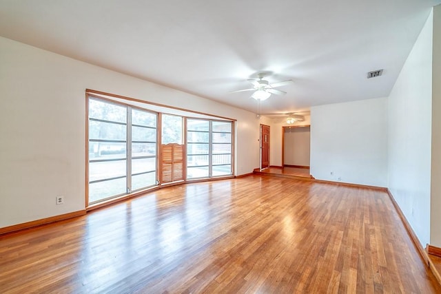 empty room with ceiling fan and light hardwood / wood-style flooring