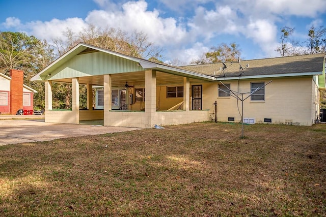 rear view of property featuring covered porch and a lawn