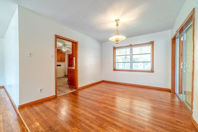 unfurnished room featuring washer / clothes dryer and light hardwood / wood-style floors