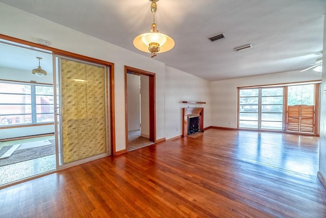 unfurnished living room with ceiling fan, plenty of natural light, and wood-type flooring