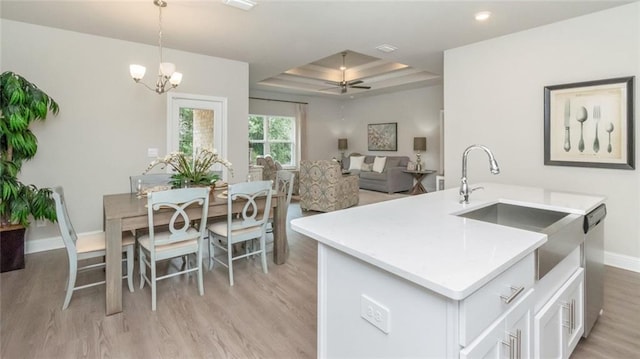 10676 Relic Rd N, Mobile, AL 36608 - kitchen featuring light wood-type flooring, light countertops, white cabinets, dishwasher, and pendant lighting