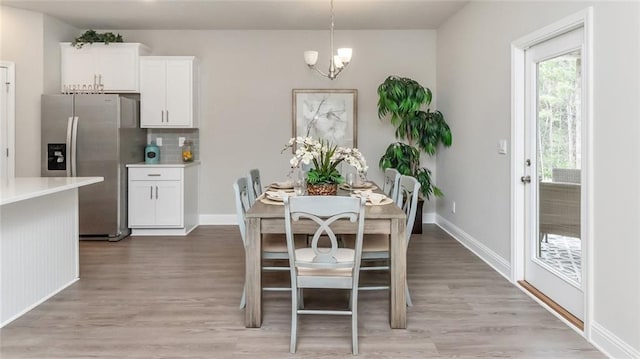 10676 Relic Rd N, Mobile, AL 36608 - dining room with light wood-style flooring, a chandelier, and baseboards