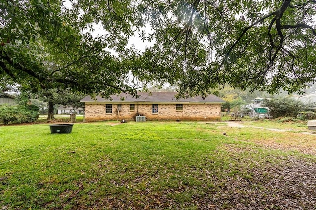 back of house with a yard and central AC