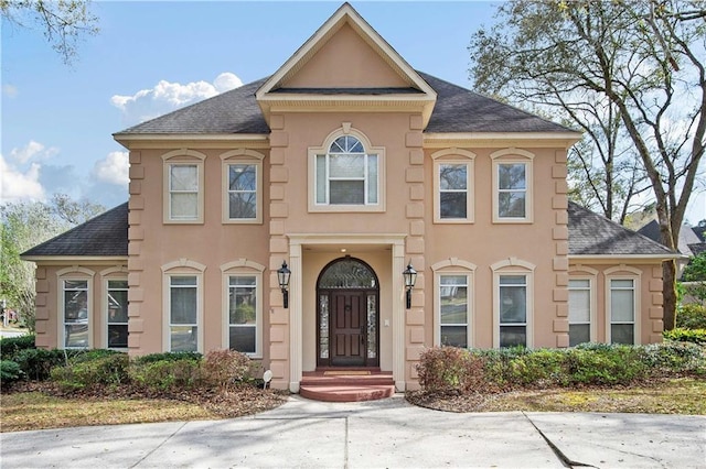 view of front of property with stucco siding and a shingled roof