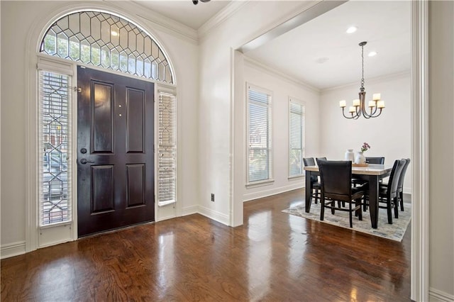 foyer featuring baseboards, wood finished floors, a chandelier, and crown molding