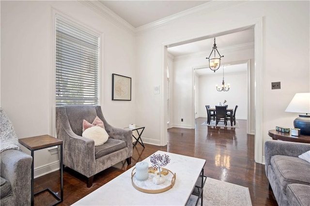 living area with a notable chandelier, wood finished floors, baseboards, and ornamental molding