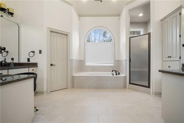 full bath with tile patterned floors, a stall shower, vanity, and a garden tub