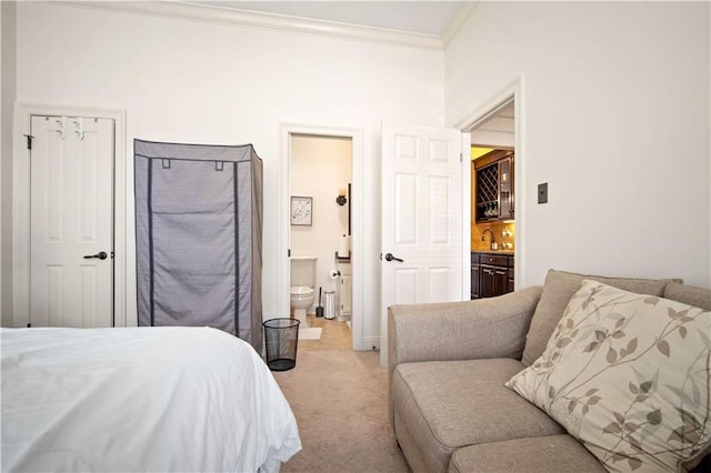 bedroom featuring ensuite bathroom, crown molding, and carpet floors