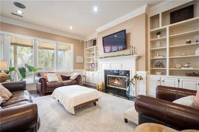 living area with wood finished floors, built in shelves, a fireplace, and ornamental molding