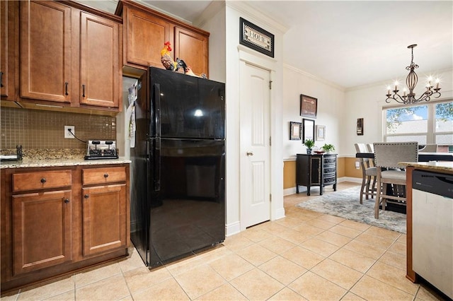 kitchen with freestanding refrigerator, brown cabinets, dishwasher, a notable chandelier, and light tile patterned flooring