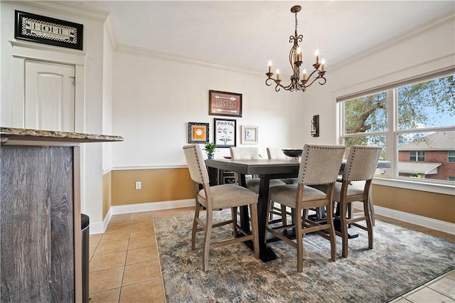 dining space featuring light tile patterned floors, baseboards, ornamental molding, and a notable chandelier