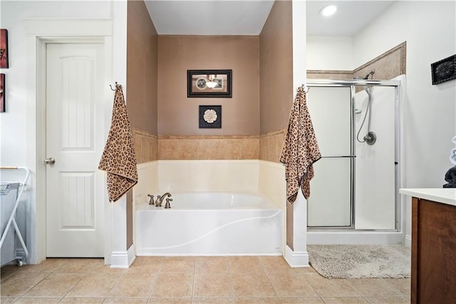 bathroom with tile patterned floors, a shower stall, vanity, baseboards, and a garden tub