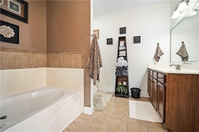 bathroom featuring a bath, tile patterned flooring, vanity, and baseboards