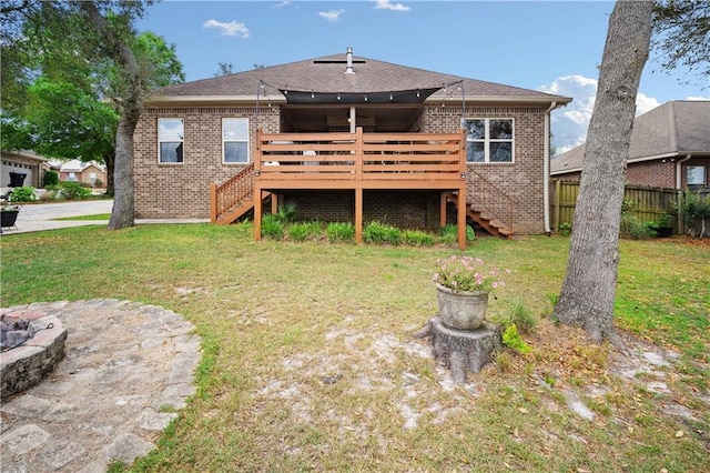rear view of property featuring a lawn, stairway, a deck, and brick siding
