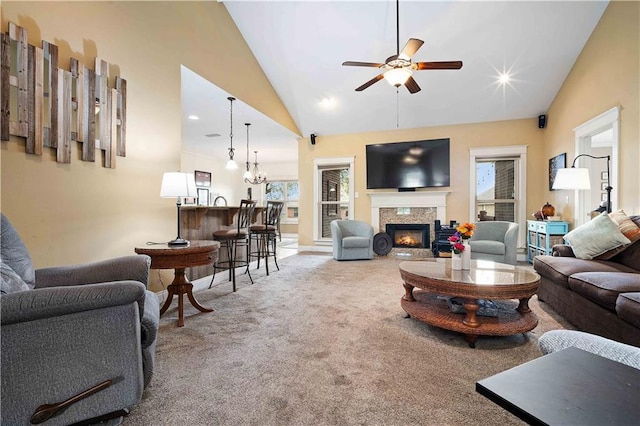 living room with ceiling fan, baseboards, carpet floors, a premium fireplace, and high vaulted ceiling