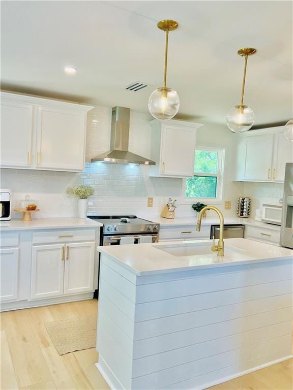 2026 Norman Ln, Gulf Shores, AL 36542 - kitchen featuring visible vents, a sink, wall chimney range hood, light wood-type flooring, and electric range