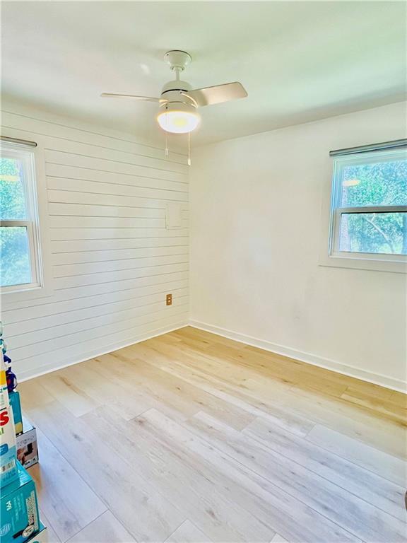 2026 Norman Ln, Gulf Shores, AL 36542 - empty room with a wealth of natural light, light wood-type flooring, ceiling fan, and baseboards
